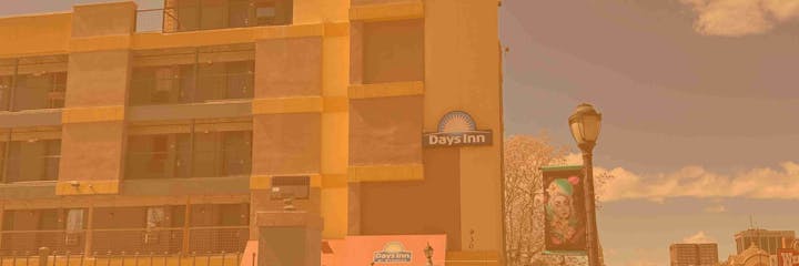 A hotel building with a "Days Inn" sign, street lamp, and colorful urban banner.