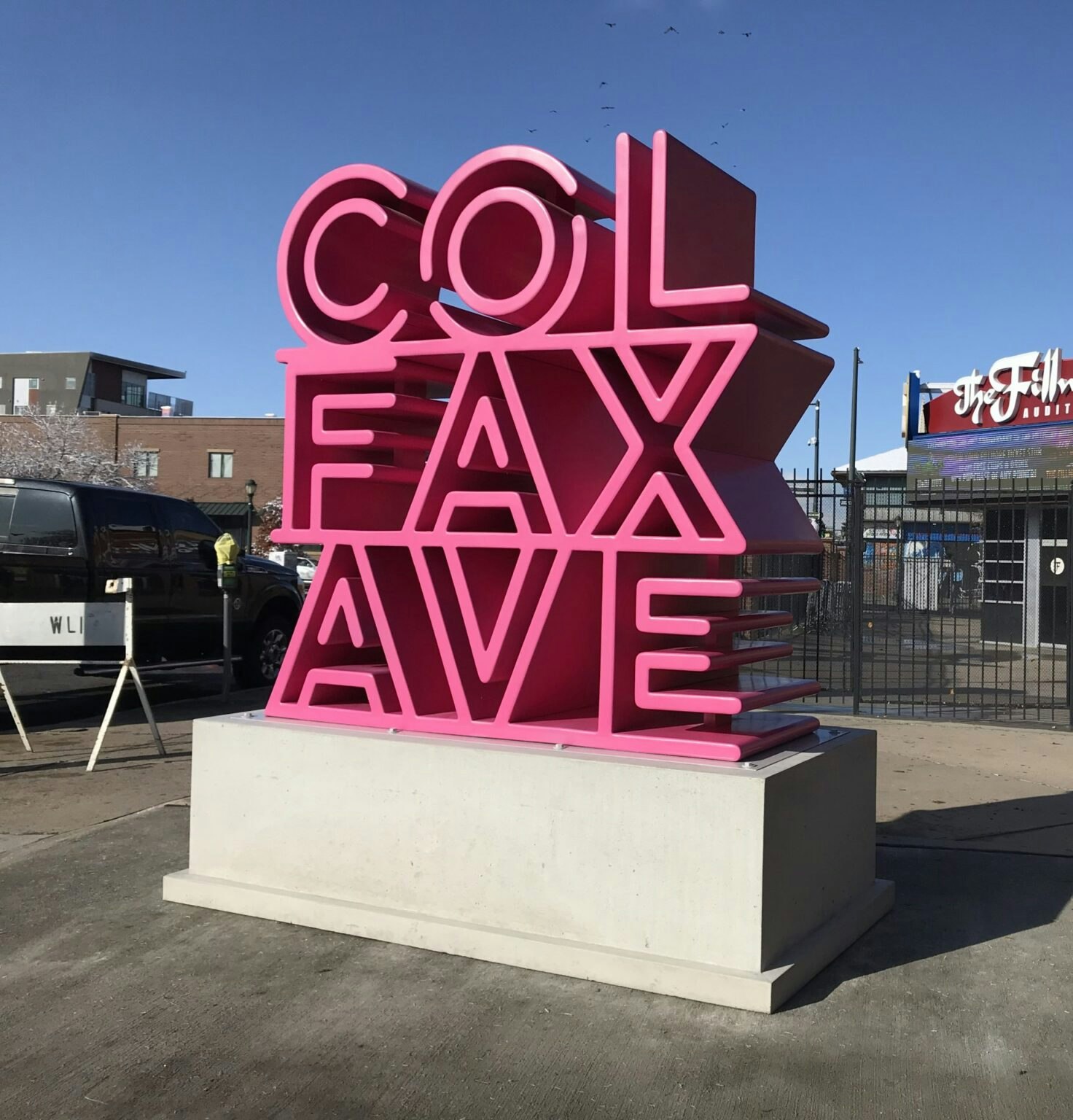 Large pink sculpture with the words "COLFAX AVE" stacked.