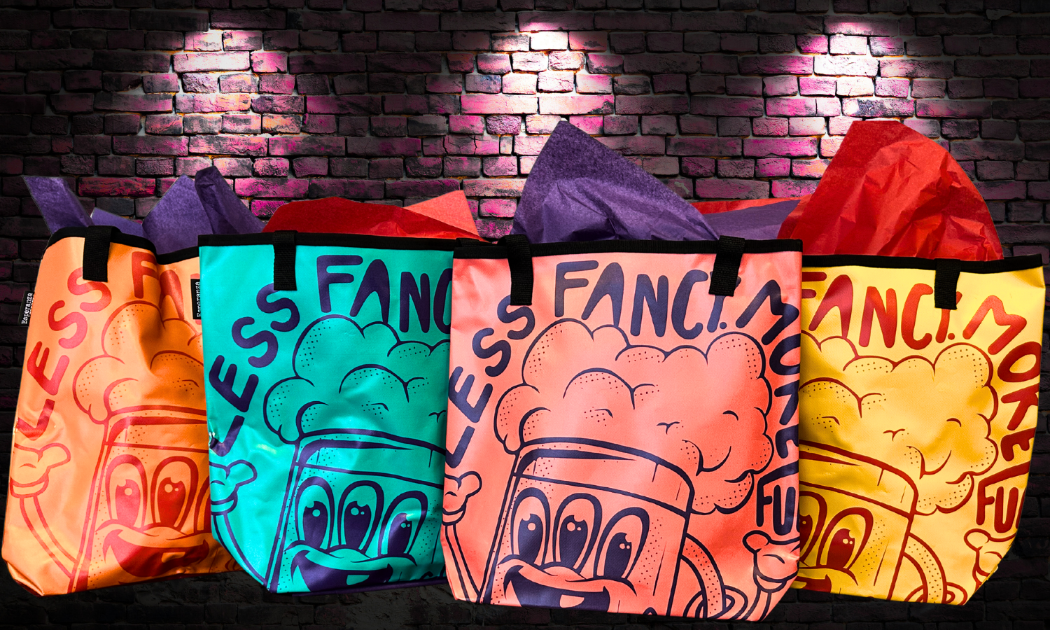 The image features colorful tote bags with playful designs and the phrase "Less Fancy, More Fun" against a textured brick background.