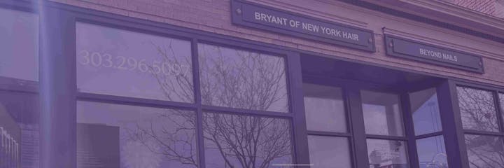 Storefronts with signs: "BRYANT OF NEW YORK HAIR" and "BEYOND NAILS," with reflections and a phone number visible.