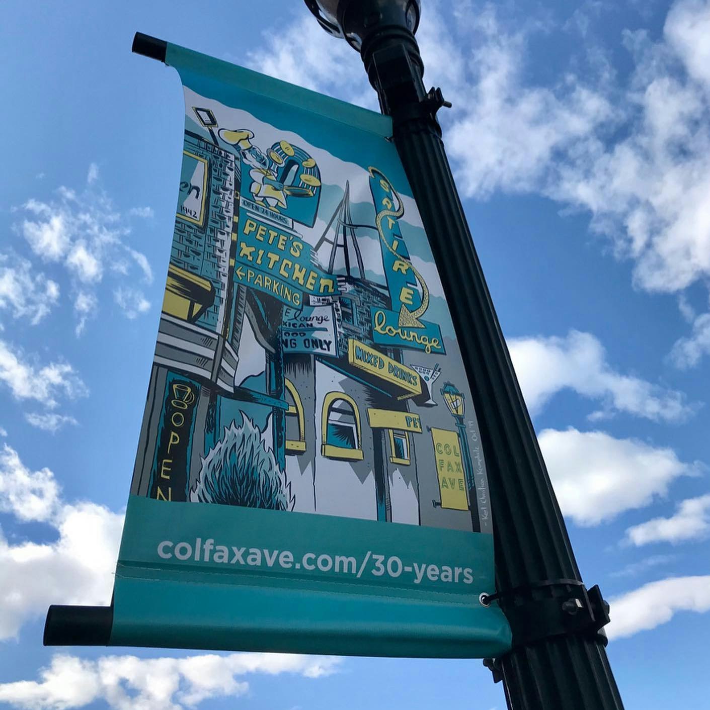 Illustrated banner on a lamppost with signs for Pete's Kitchen and Satire Lounge, blue sky background.