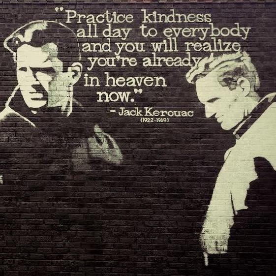 A mural with Jack Kerouac quote about kindness, featuring two figures on a brick wall.