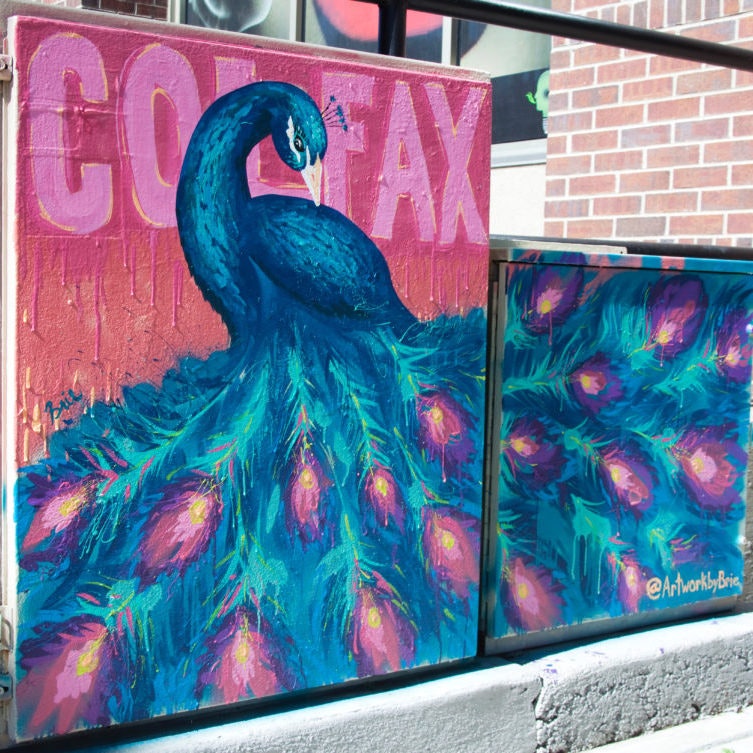 A vibrant mural of a peacock with bright feathers and "Colfax" text in the background.