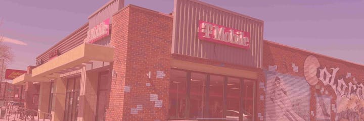 A T-Mobile store with a brick facade and mural, including a Colorado-themed artwork.