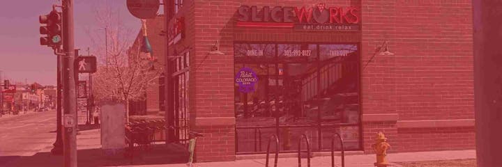 Street view with a traffic light, pedestrian signal, and a restaurant called SliceWorks with a "Pabst Colorado Beer" sign.