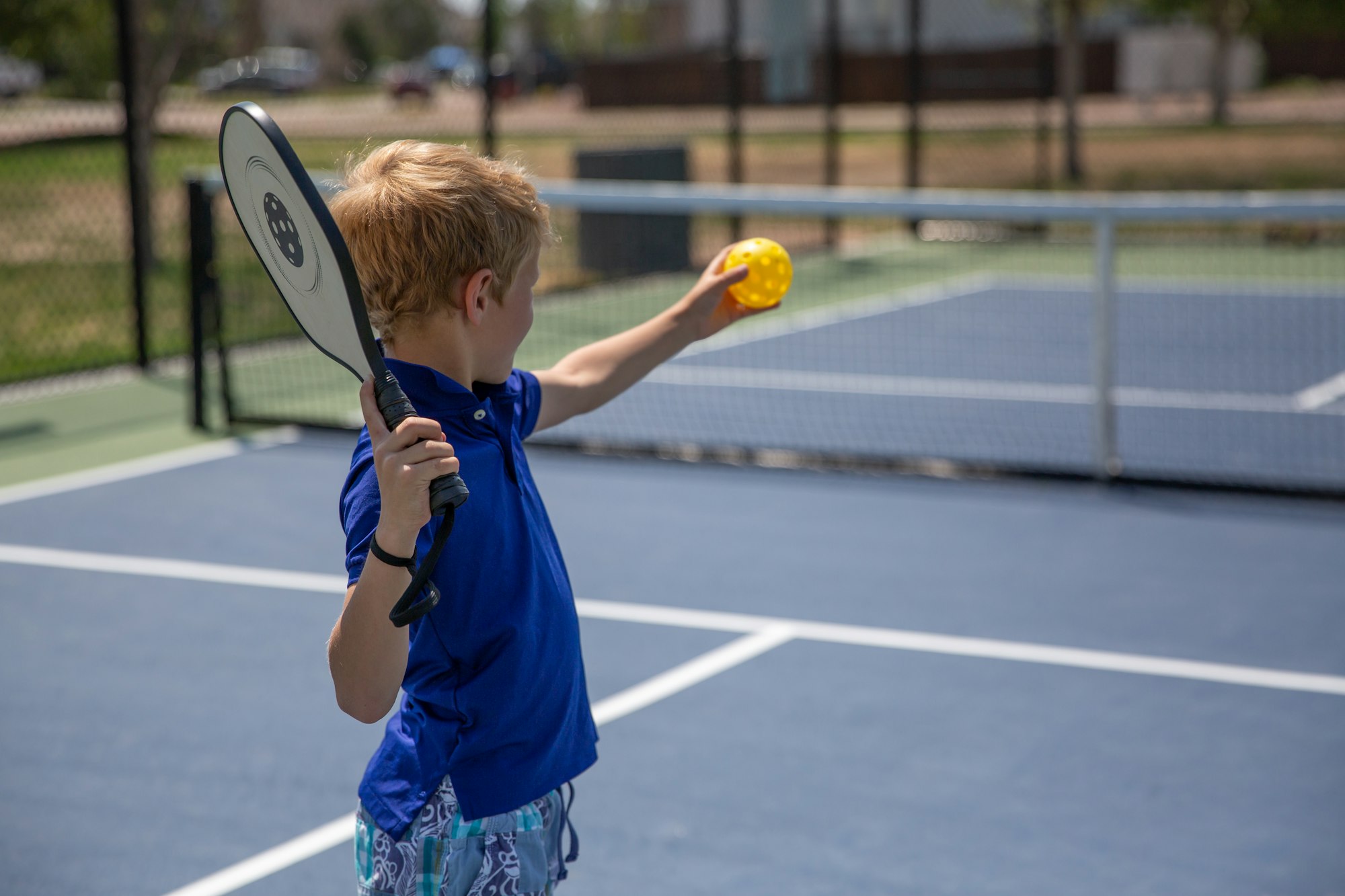 May contain: ball, sport, tennis, tennis ball, body part, finger, hand, person, boy, child, male, and racket