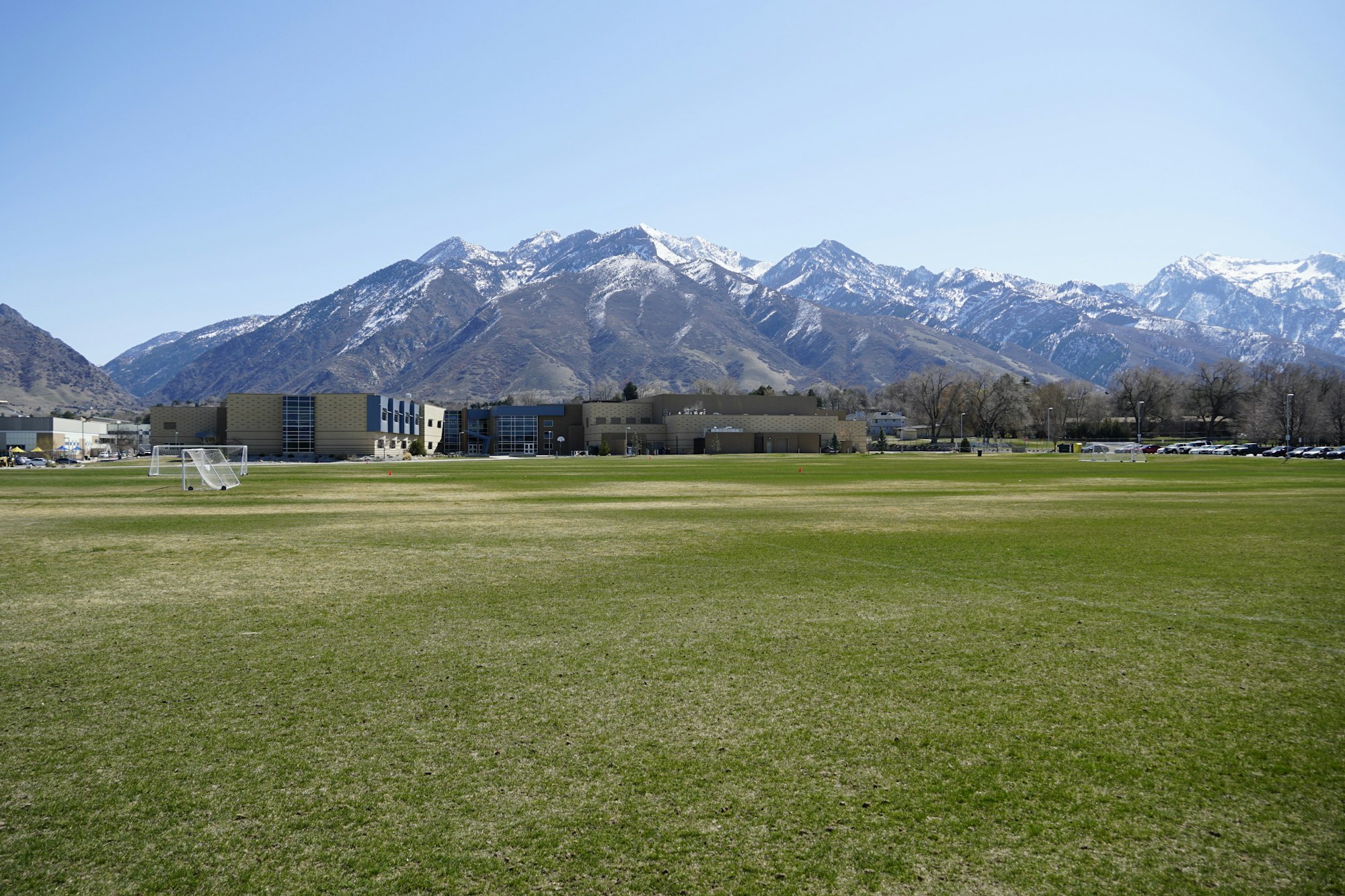 May contain: grass, plant, lawn, mountain, mountain range, nature, outdoors, field, peak, airport, car, transportation, and vehicle