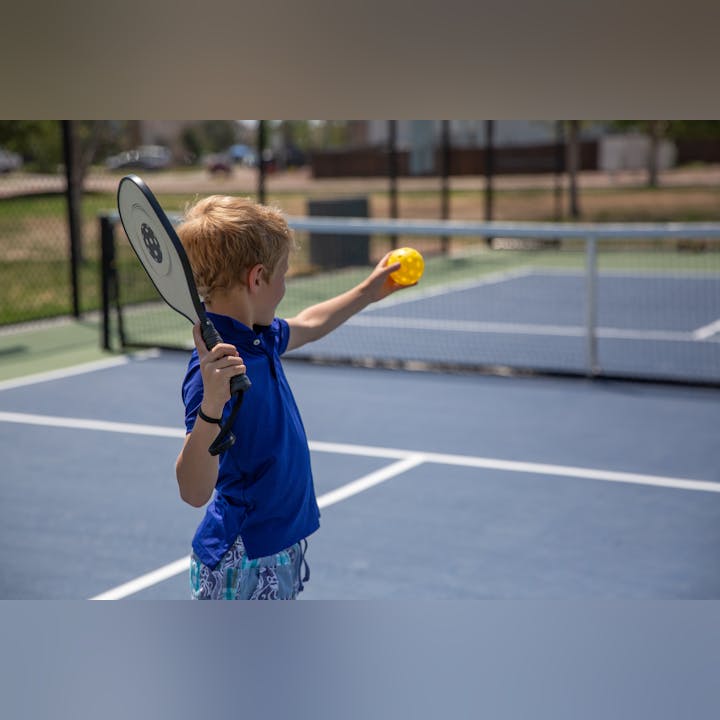 May contain: ball, sport, tennis, tennis ball, body part, finger, hand, person, boy, child, male, and racket