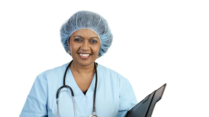 A smiling female healthcare professional wearing scrubs and a surgical cap, holding a clipboard or medical record.