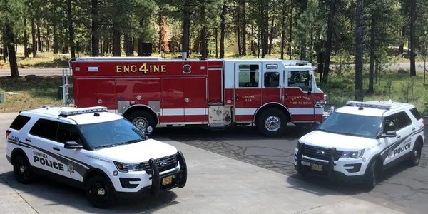 A fire engine and two police SUVs parked outside.