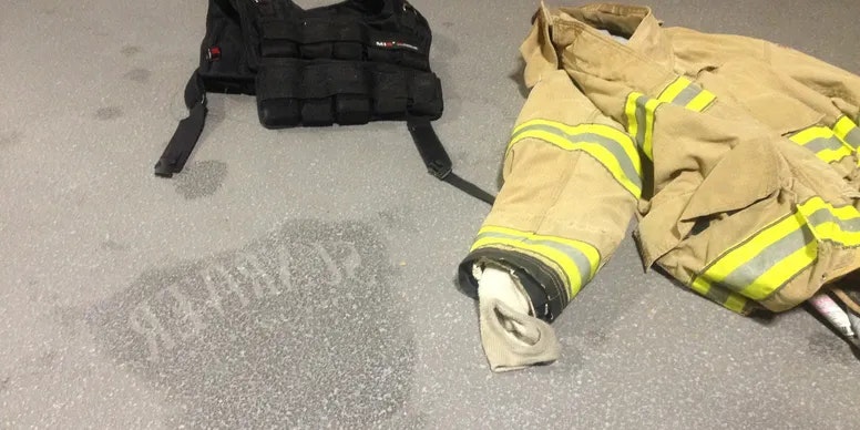 Firefighter's gear on the ground, including a jacket and a vest.