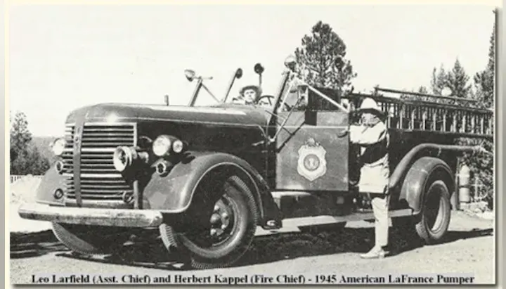 Vintage photo of two firemen with a 1945 American LaFrance Pumper fire truck.