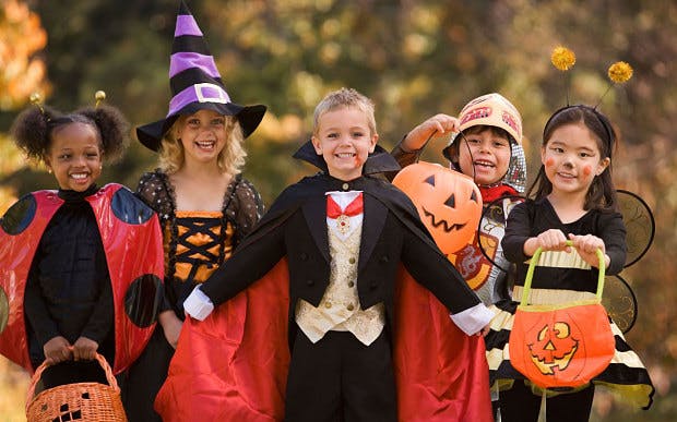 Children in Halloween costumes with candy buckets.