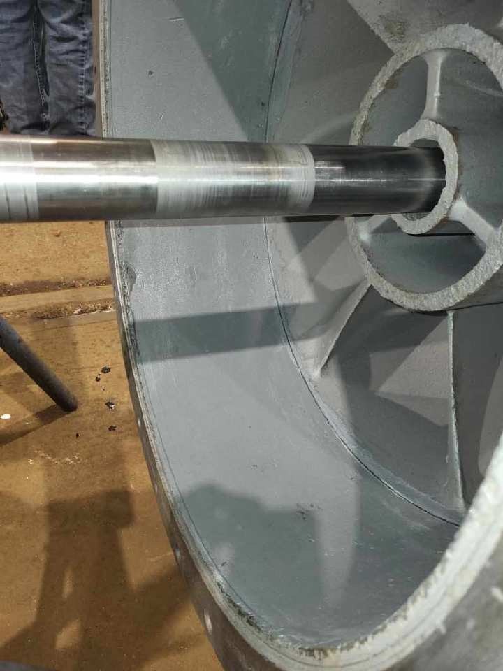 The image shows a metallic cylinder inside a larger, circular casing, likely part of a mechanical or industrial assembly.