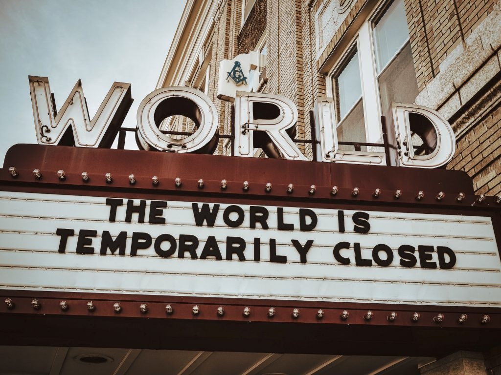 A marquee sign reads "THE WORLD IS TEMPORARILY CLOSED" under large letters spelling "WORLD."