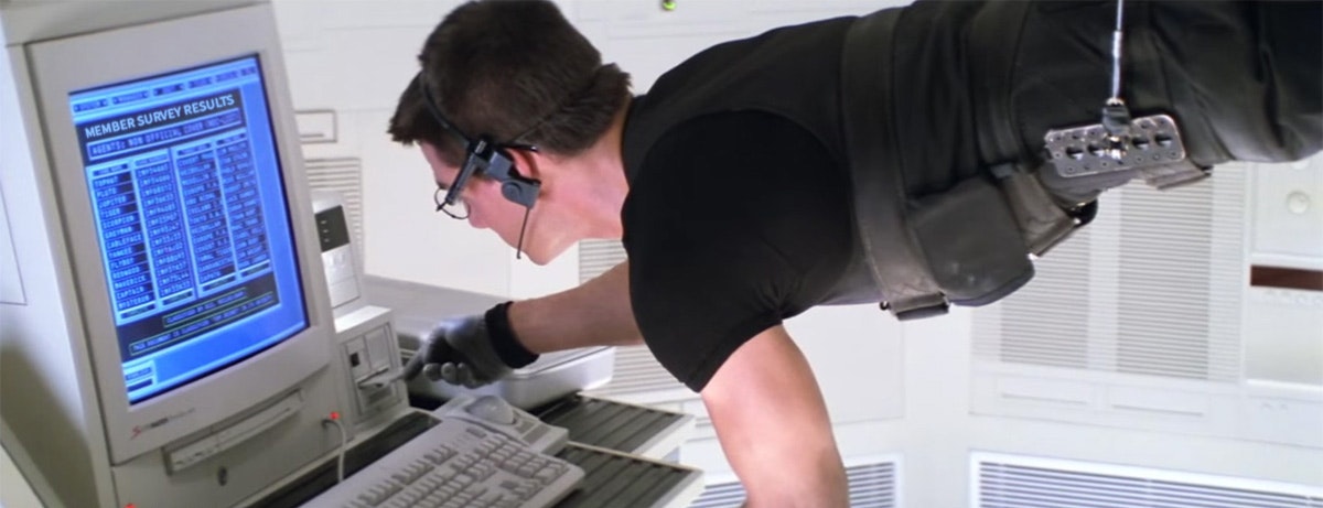 Mission Impossible. Ethan Hunt is suspended in mid-air, taking Member Survey Results from a computer.