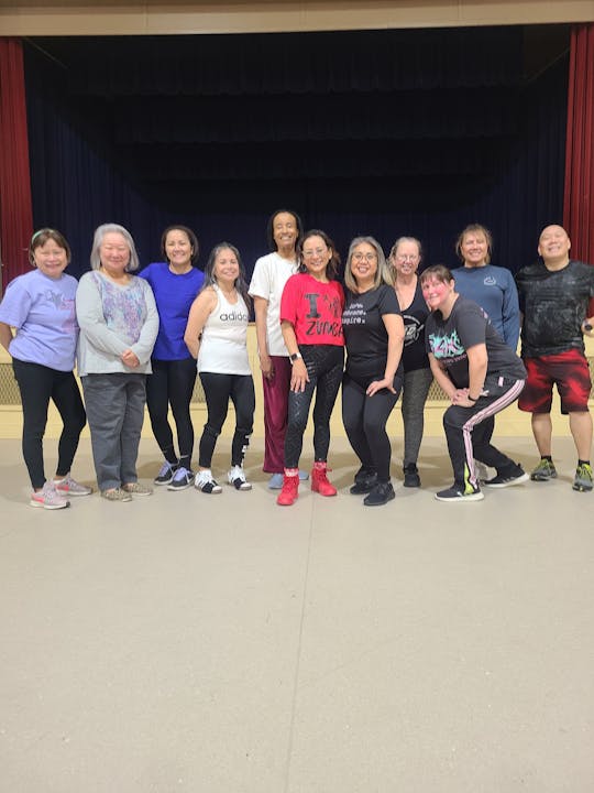 A group of people in workout attire posing indoors.