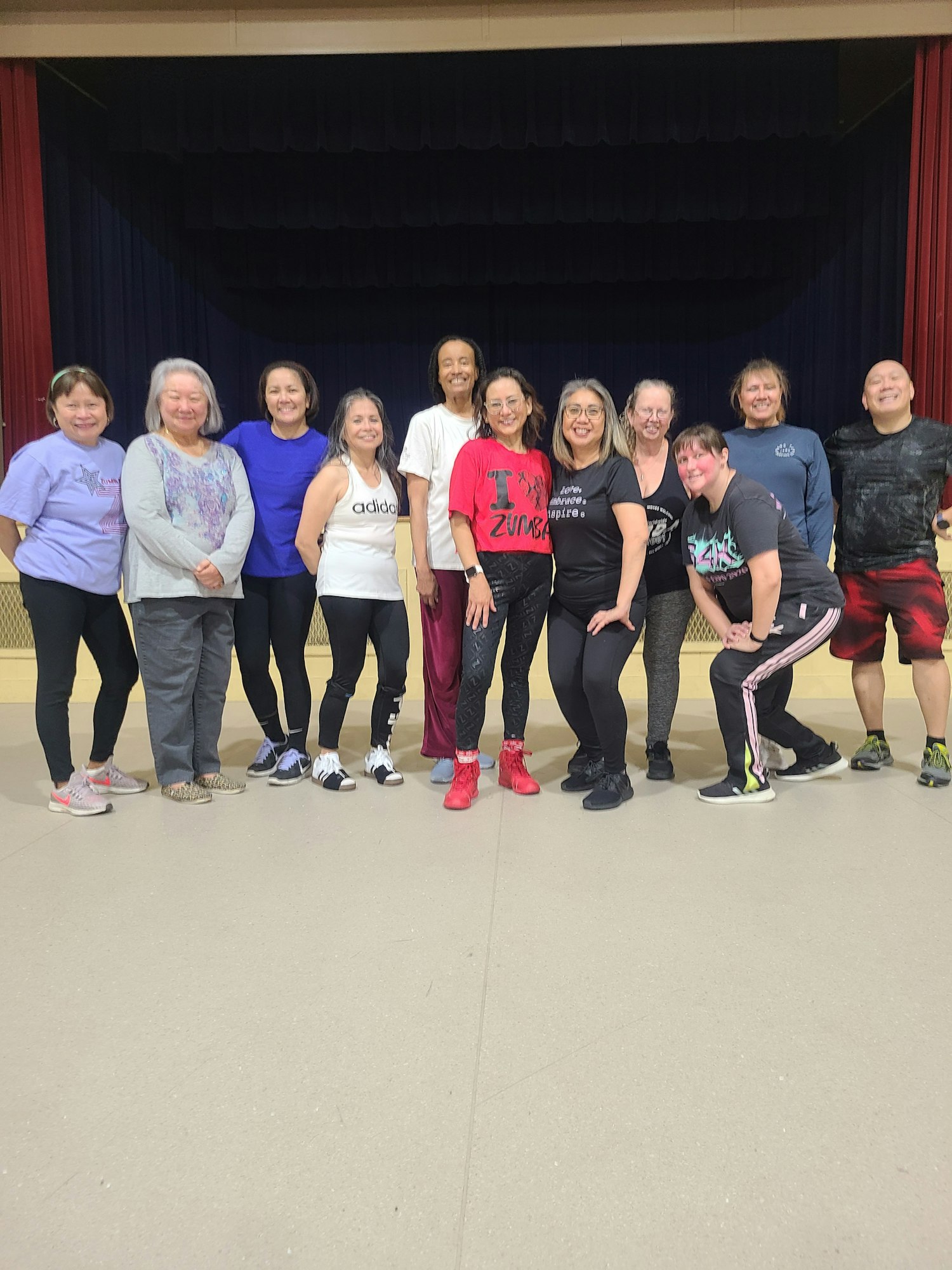 A group of people in workout attire posing indoors.