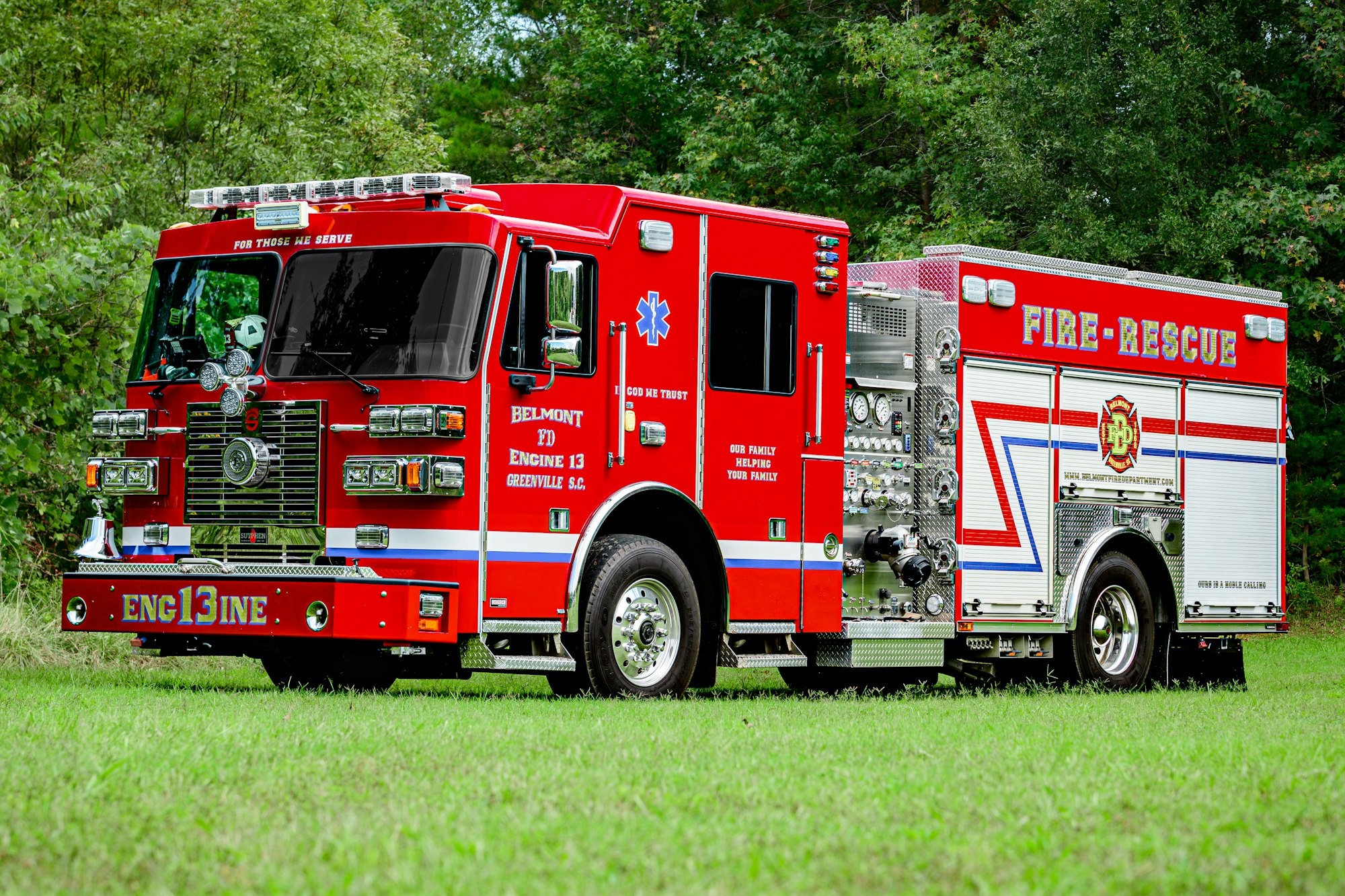 Red fire truck labeled "Fire-Rescue" in grassy area.