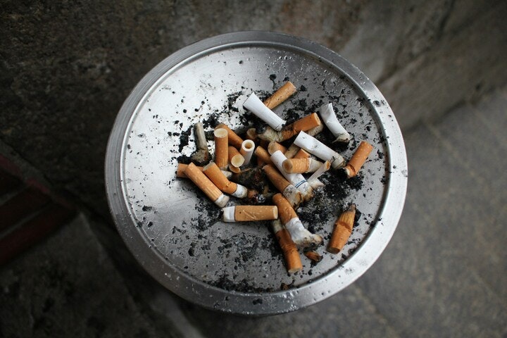 A metal ashtray full of extinguished cigarette butts.