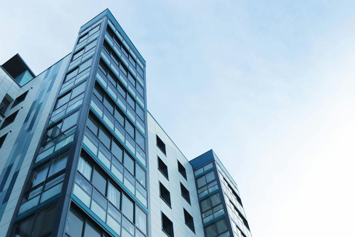 Modern building with glass facade against a clear sky.