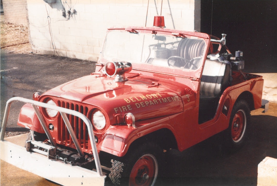 A red fire department jeep with equipment and a light on top.