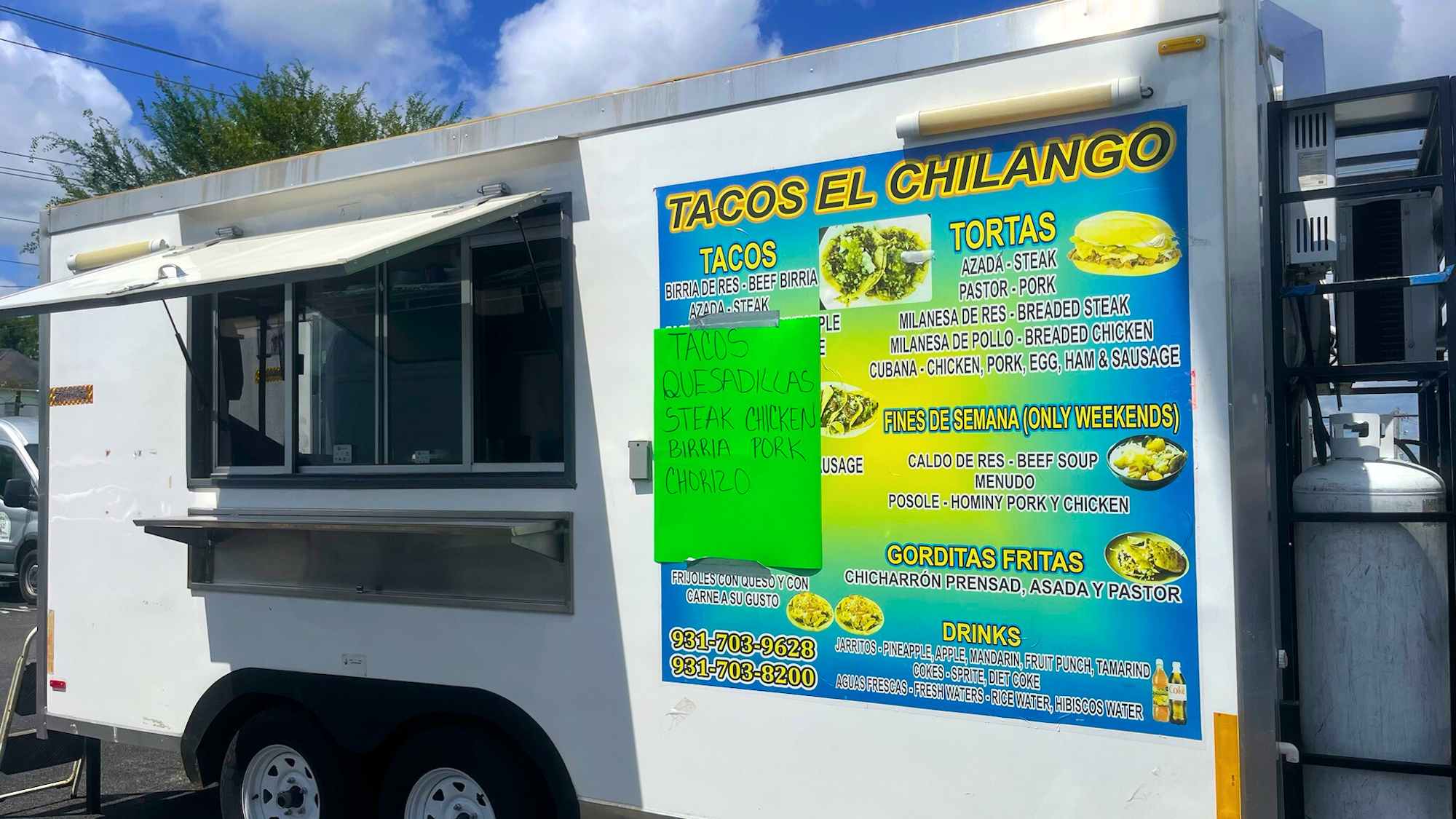 A food truck offering tacos, tortas, quesadillas, and drinks with a menu displayed on the side.
