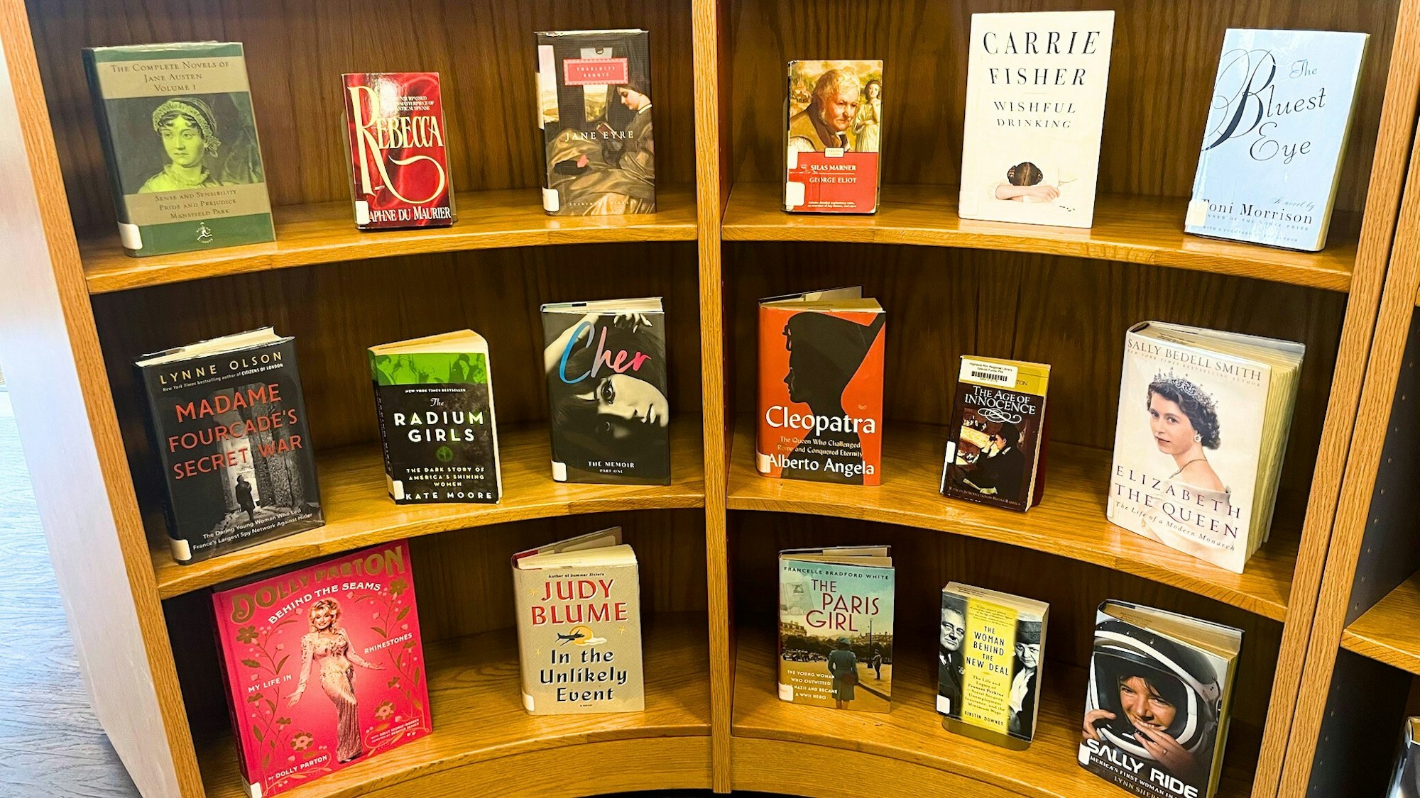 A bookshelf filled with various books, including novels and biographies, covering diverse themes and authors.