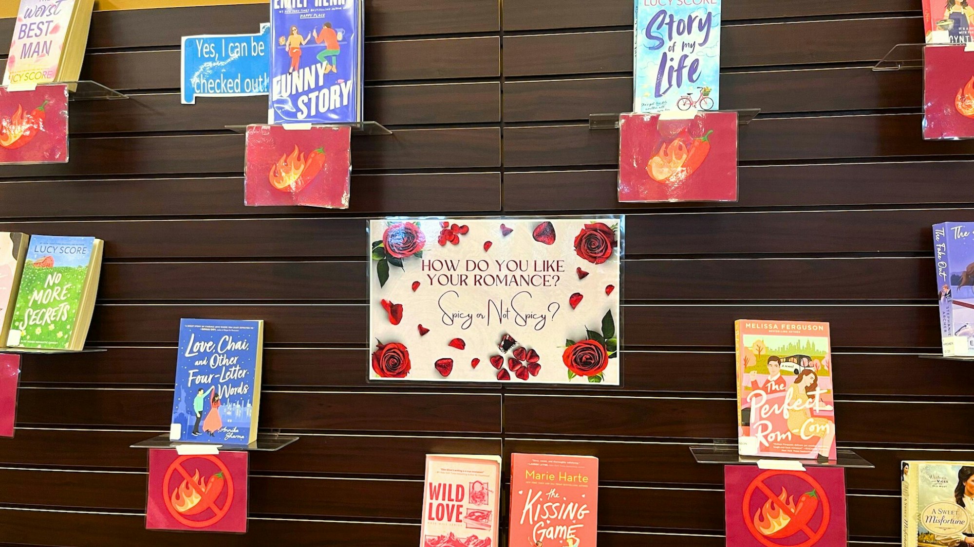 A display promoting romance books, asking preferences for "Spicy or Not Spicy?" with various titles featured.