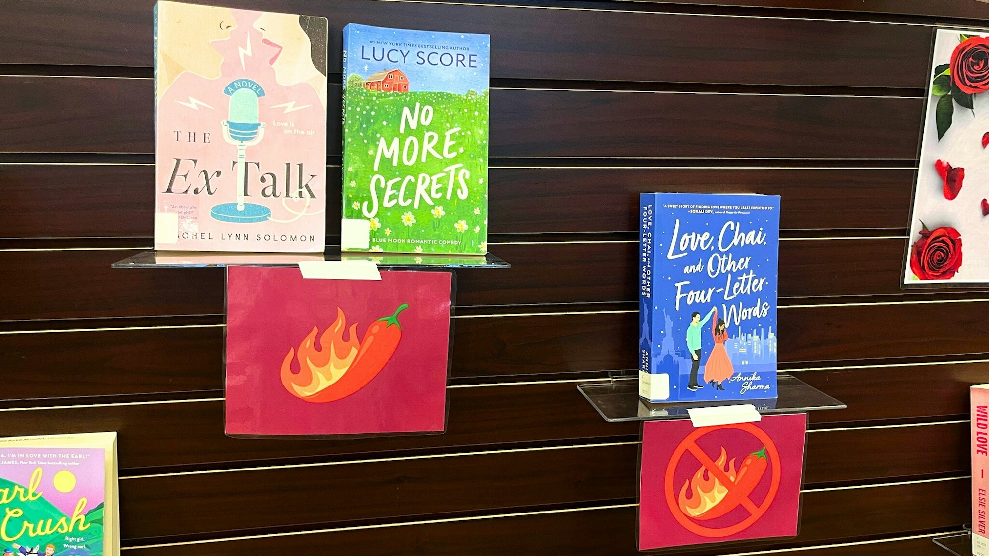 A display of several books, including "The Ex Talk," "No More Secrets," and "Love, Chai, and Other Four-Letter Words," with colorful motifs.