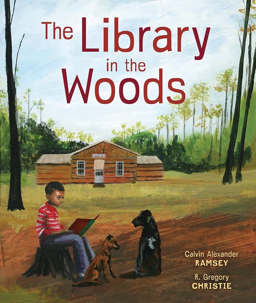 A child reads to two dogs in front of a library in the woods. Book cover: "The Library in the Woods" by Calvin Alexander Ramsey.