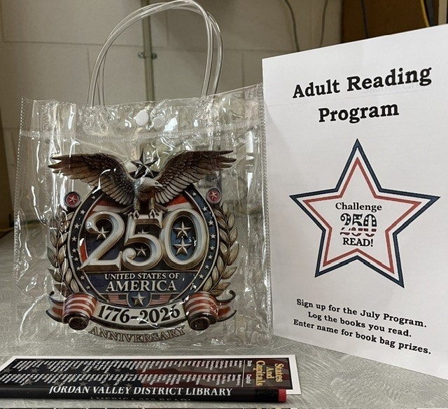 A clear bag celebrating the 250th anniversary of the U.S. (1776-2026), along with a sign for an adult reading program at a library.