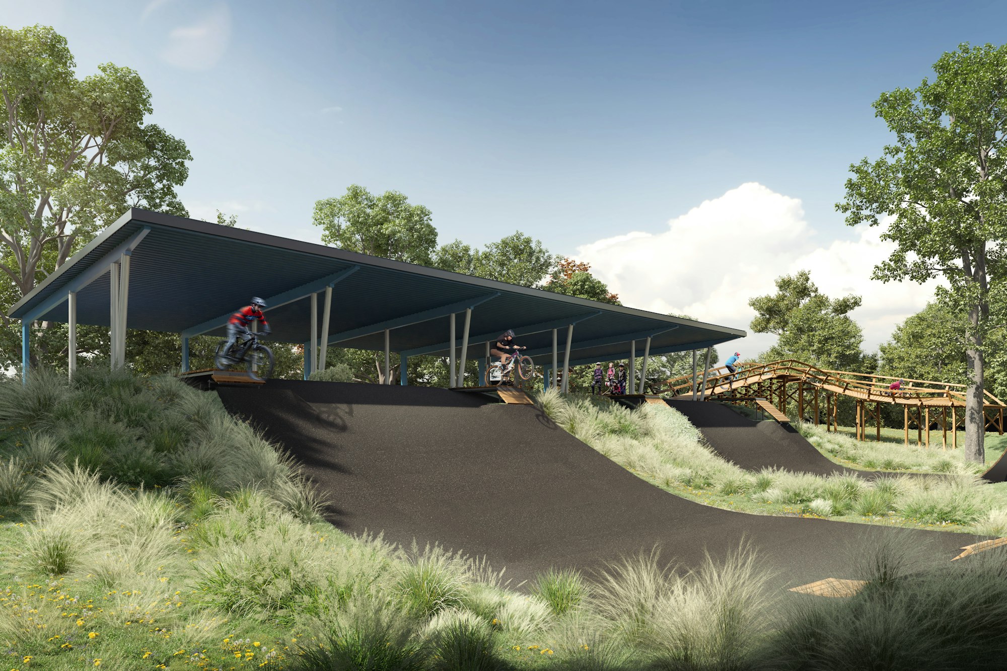 Bikers riding on a hilly track with a covered starting area surrounded by greenery and trees.