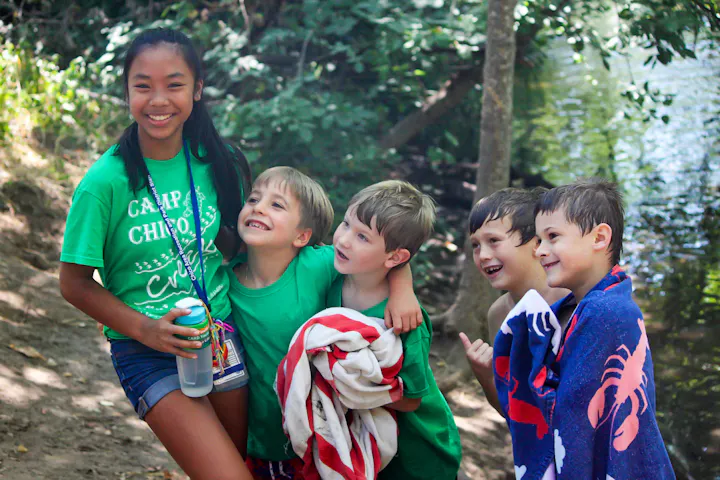 A Youth Leader poses happily for a photo with some young campers in beautiful Bidwell Park, next to the creek.