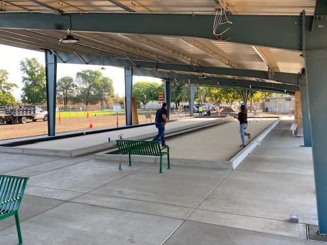 May contain: bench, furniture, transportation, truck, vehicle, person, path, sidewalk, architecture, building, outdoors, shelter, chair, and pedestrian