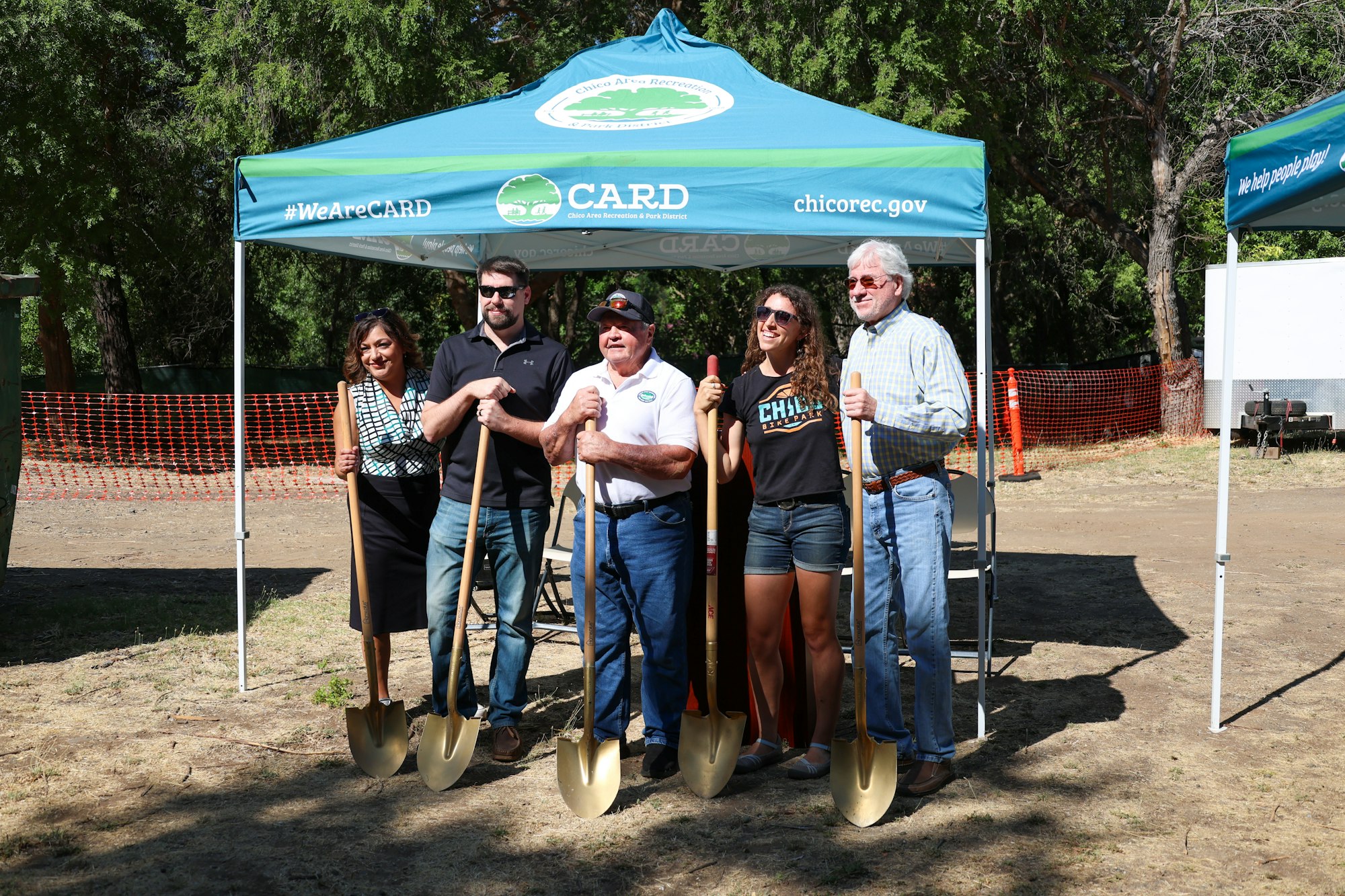 Five people with shovels at a groundbreaking event under a Chico Area Recreation District tent.
