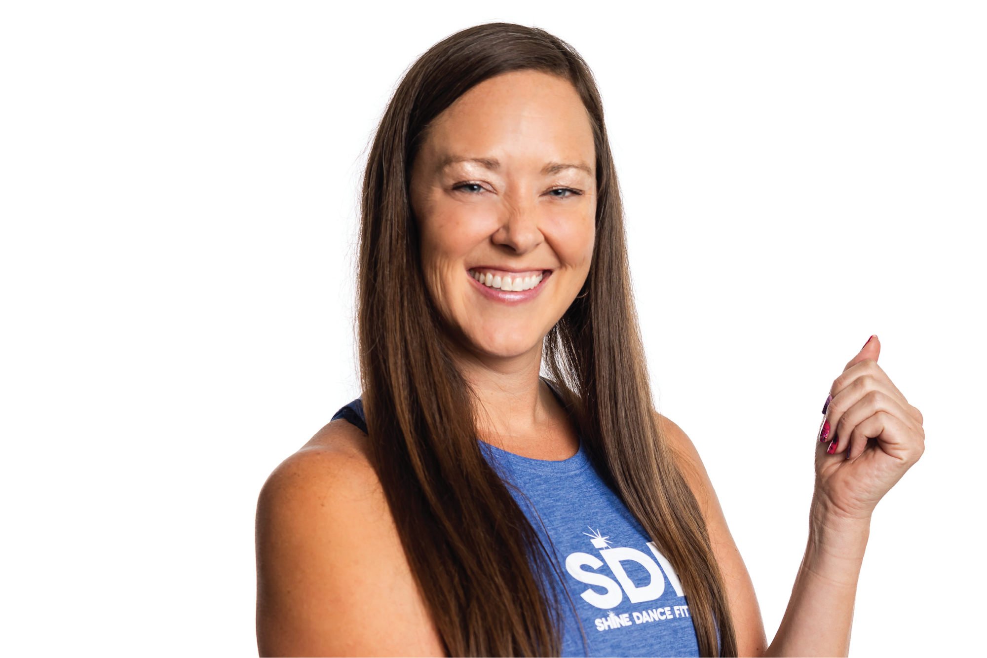 A woman with long brown hair is smiling, wearing a blue shirt that says "SHINE DANCE FITNESS."