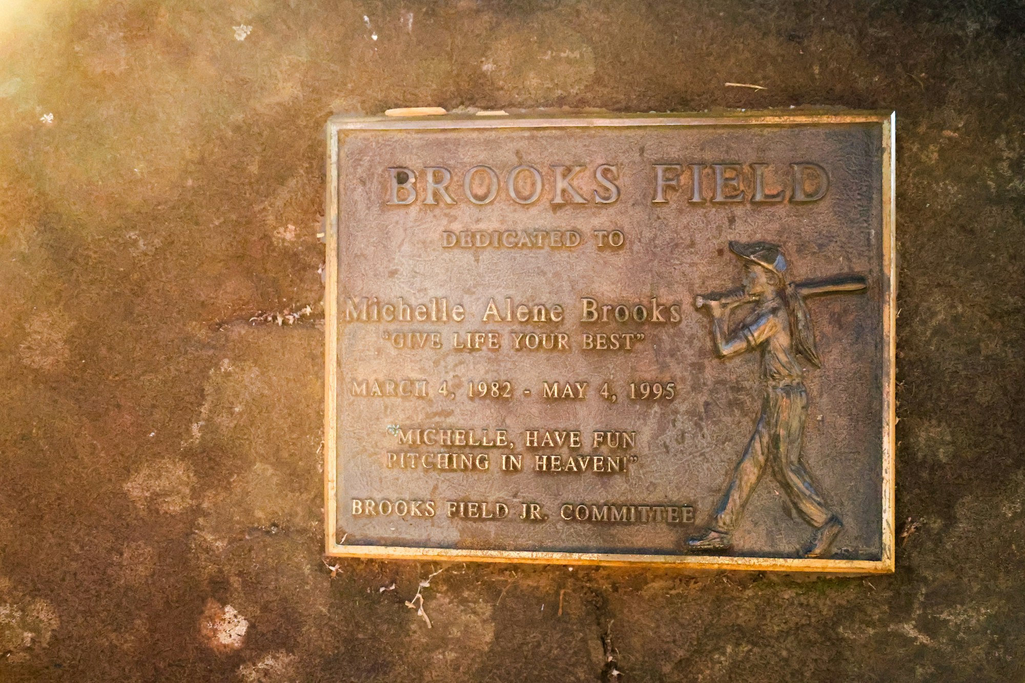 A bronze plaque dedicated to Michelle Alene Brooks at Brooks Field; includes dates and the phrase "Give life your best."