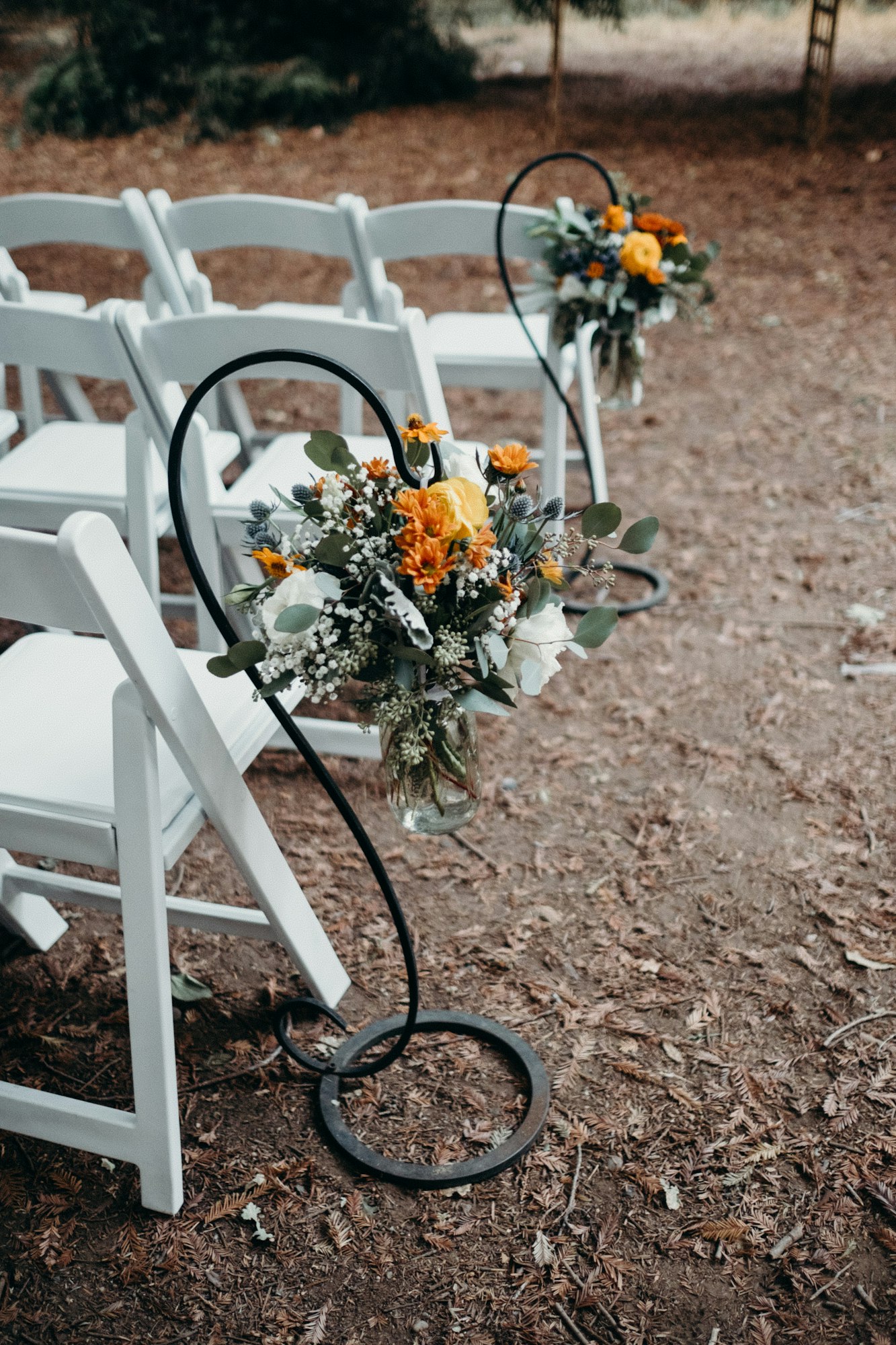 White chairs with floral arrangements for a wedding or event.