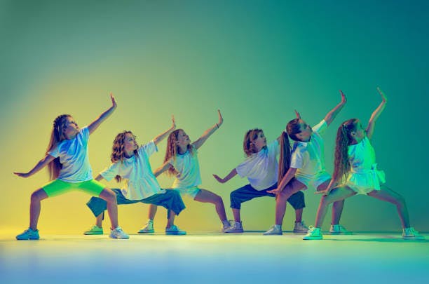 Group of children dancing in colorful light.
