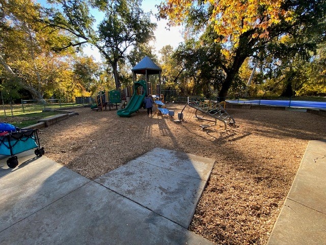 May contain: grass, nature, outdoors, park, plant, play area, outdoor play area, and person