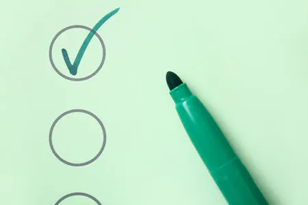 A checklist with one ticked box and a green marker pen.