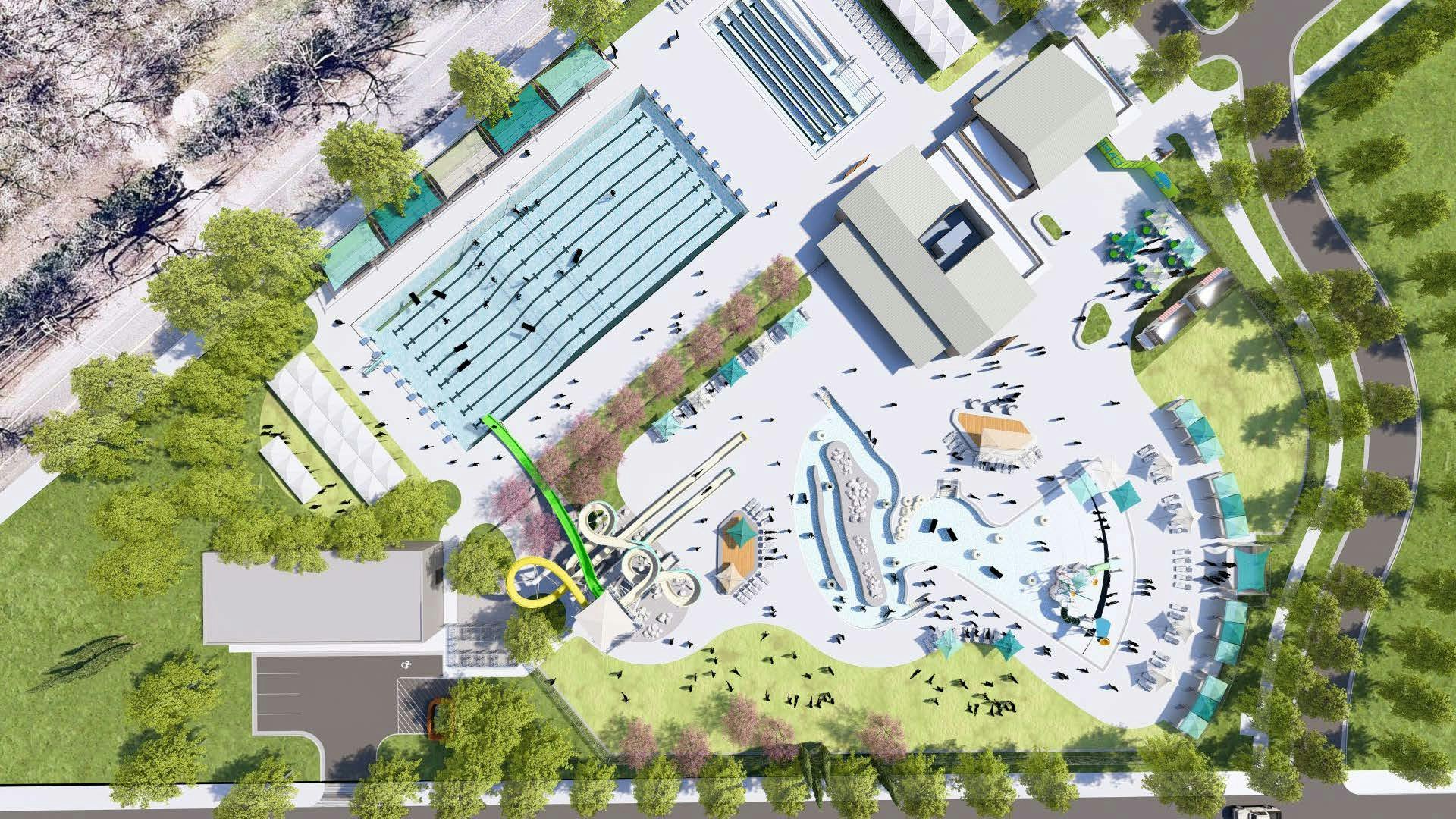 An aerial view of a swimming complex with multiple pools, slides, pathways, buildings, and surrounding trees.