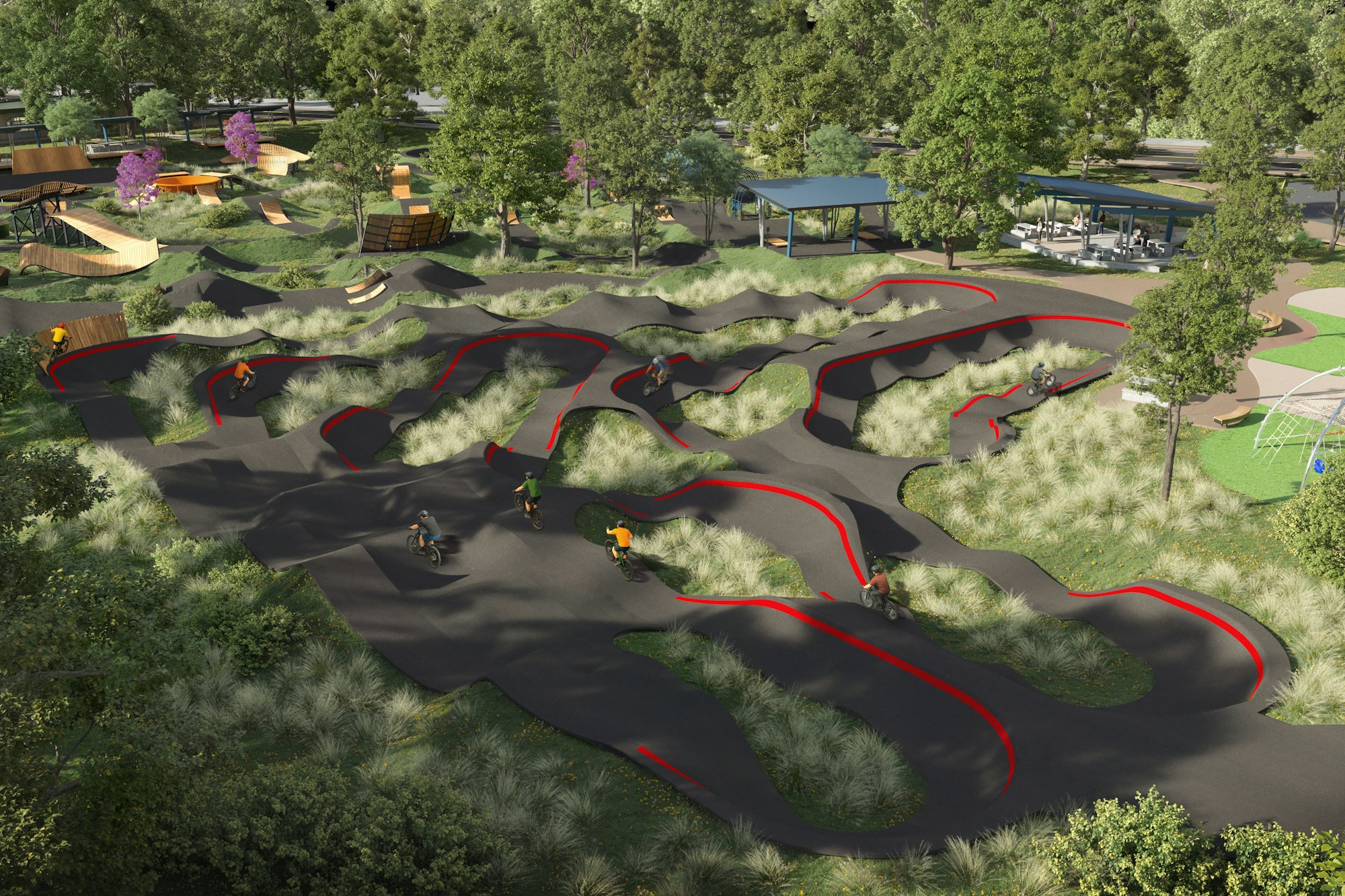 Pump track in a park with bikers riding the curved paths through grassy landscape, surrounded by trees and structures.