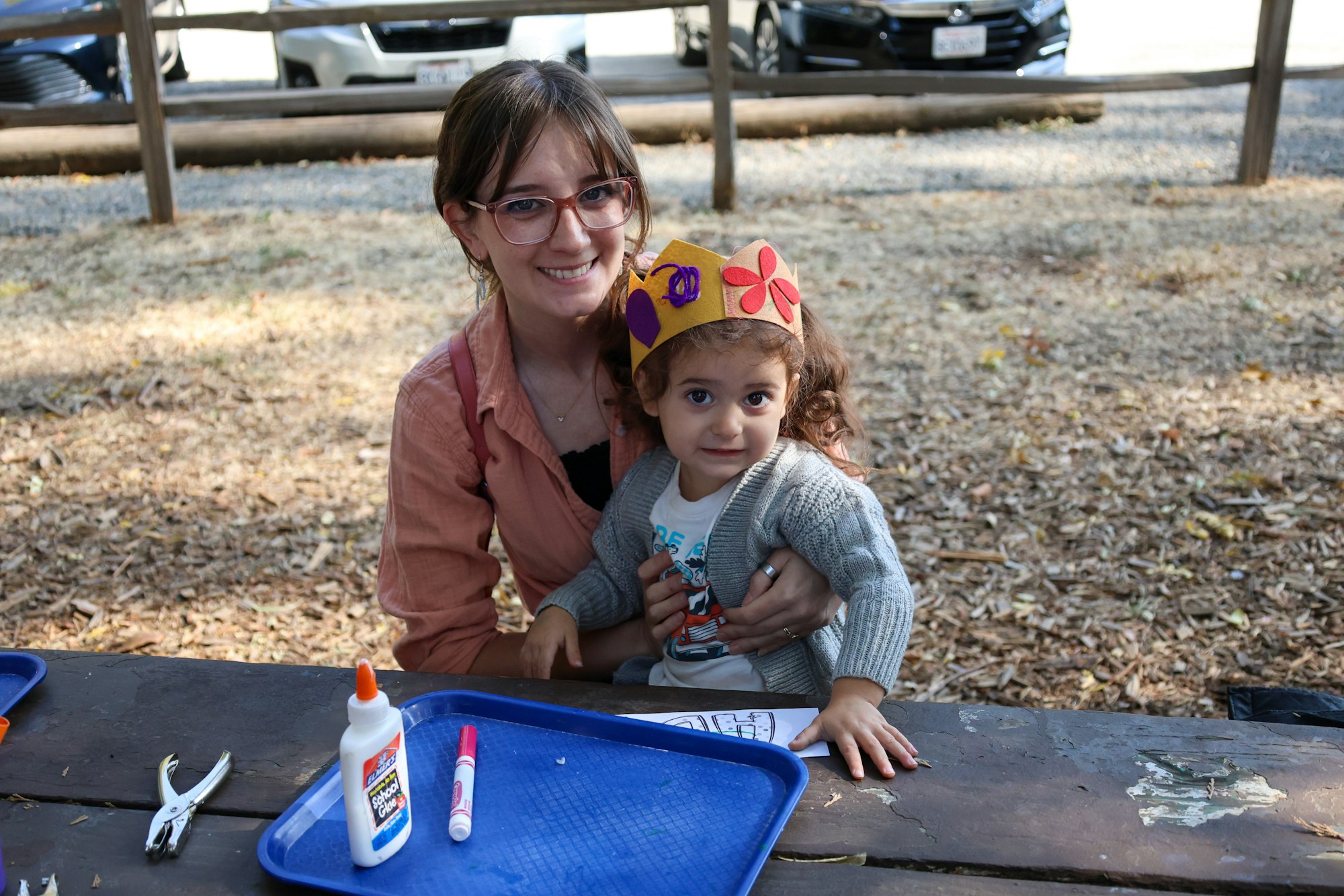 A woman and a child at a table with craft supplies.