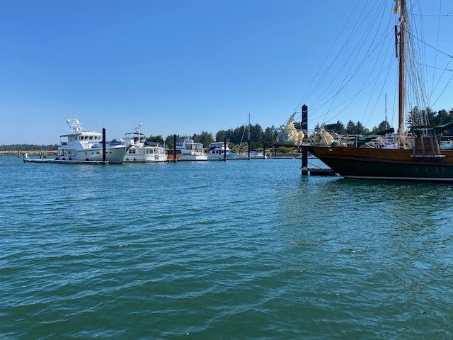 Boats moored in a calm blue harbor under a clear sky.