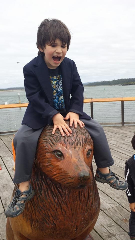 May contain: blazer, clothing, coat, jacket, water, waterfront, face, head, person, photography, portrait, formal wear, suit, pants, footwear, shoe, pier, wood, architecture, building, house, housing, porch, and deck