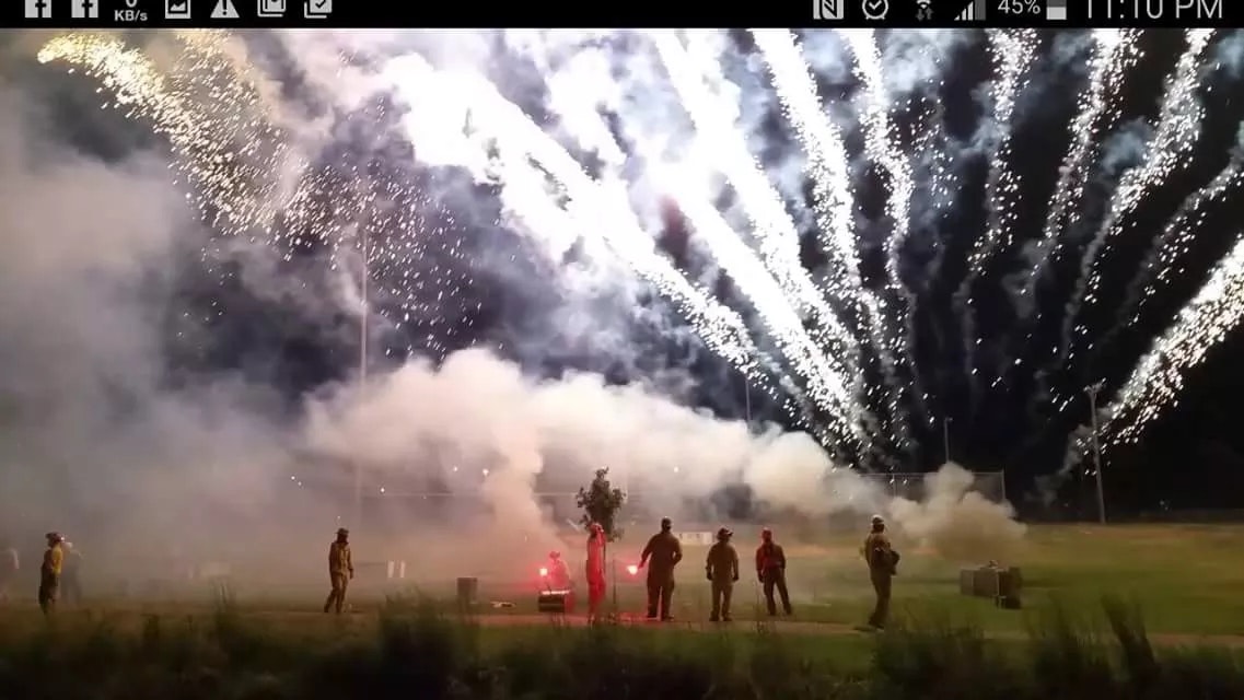 fireworks, firemen in foreground