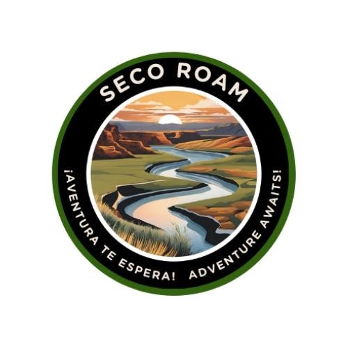 A circular logo with a desert landscape, a river, and text "SECO ROAM - ¡AVENTURA TE ESPERA! ADVENTURE AWAITS!"