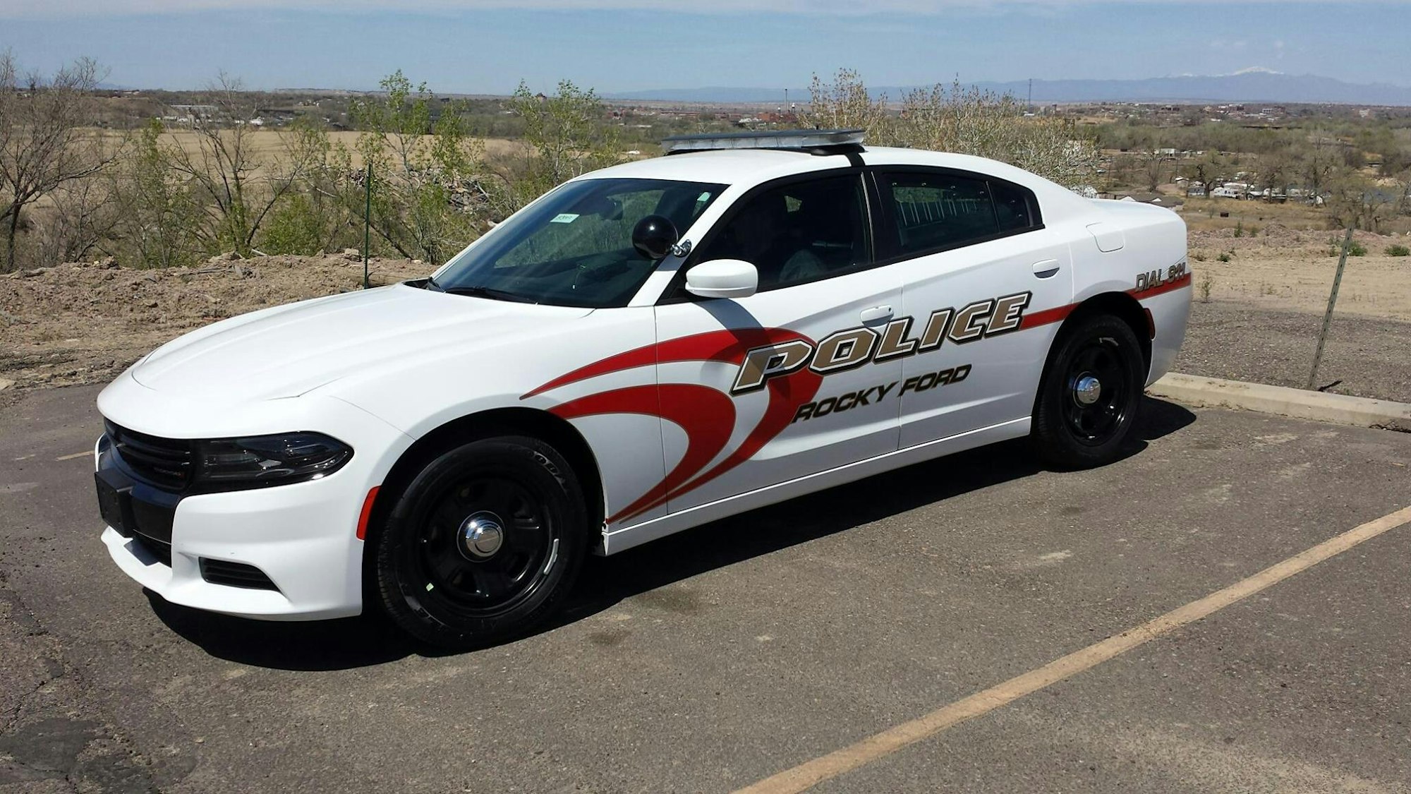 A white police car with "Rocky Ford" written on the side, parked outdoors.